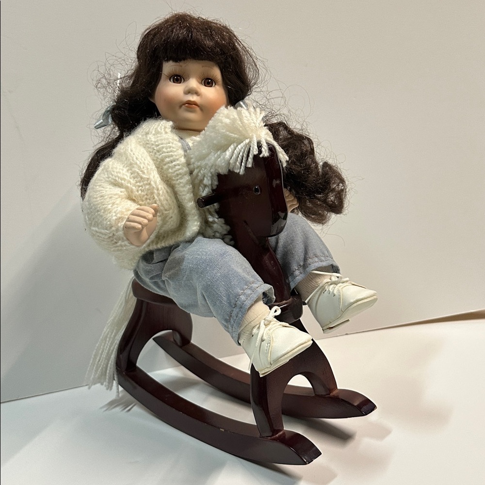 Porcelain Doll with Cream Sweater and White Shoes on Brown Rocking Horse